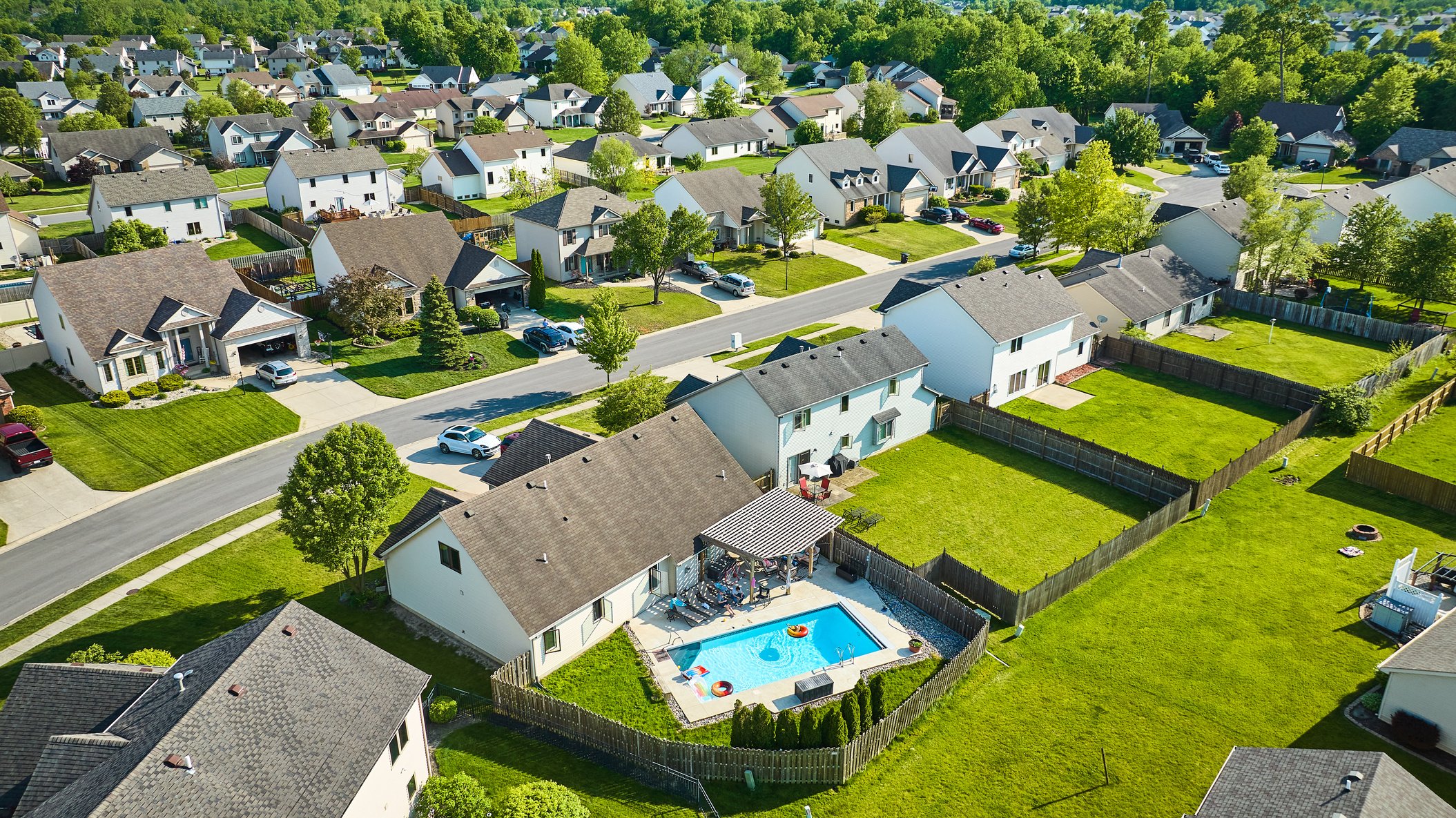 Summertime Aerial of Pool behind House in Neighborhood with Floa